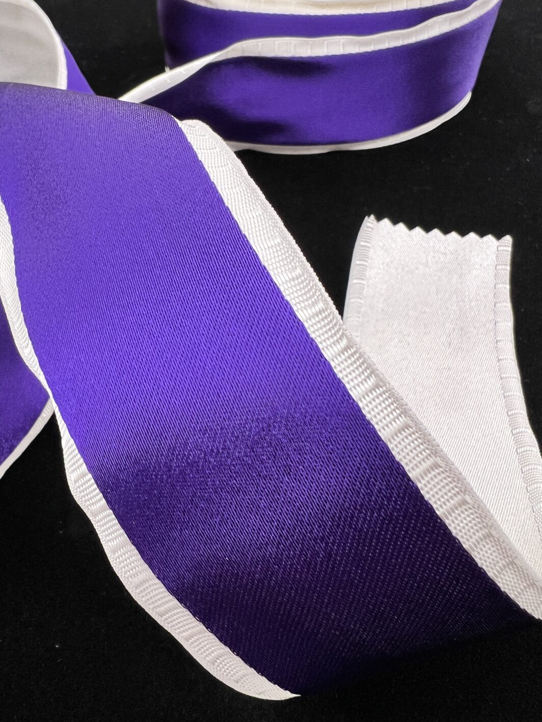 Satin Finished Woven Purple Ribbon with White Backing.